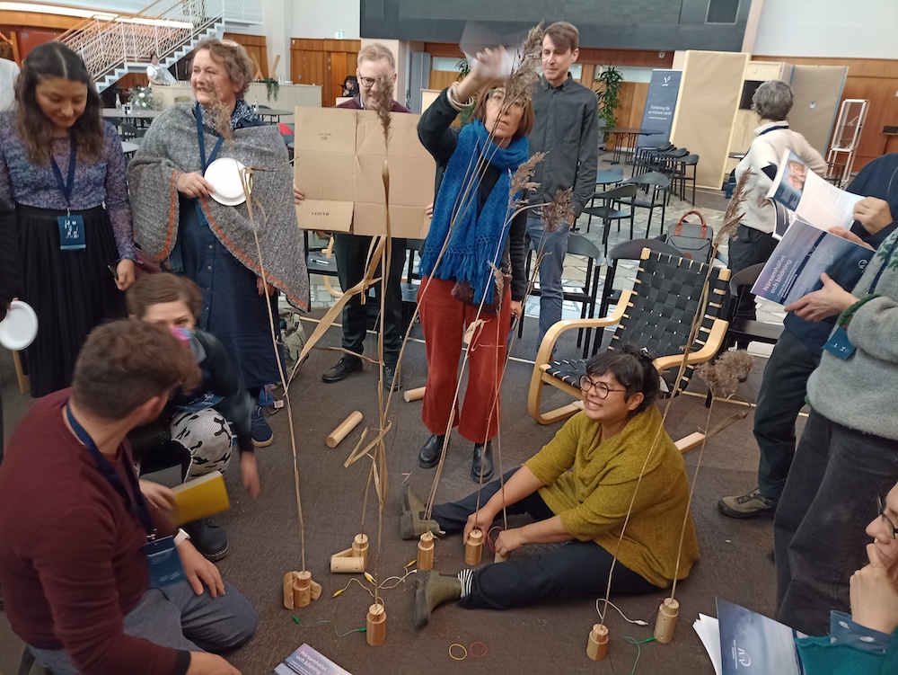 photo of workshop participants generating wind power by blowing on the electric field prototype